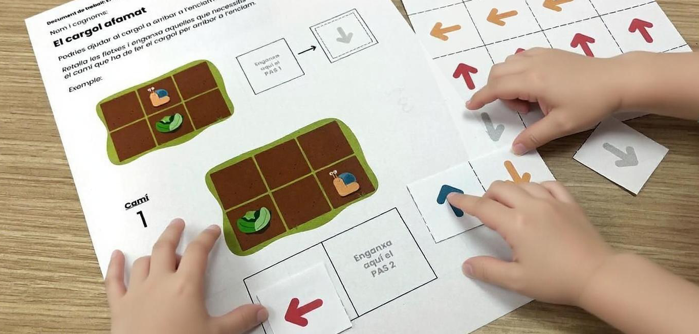 Infants seqüenciant instruccions amb fletxes per ajudar un cargol a arribar a l’enciam en una activitat de pensament computacional desendollat