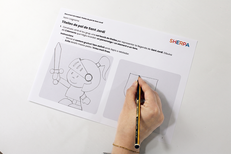 Alumna dibuixant una figura al document de treball de titelles de Sant Jordi