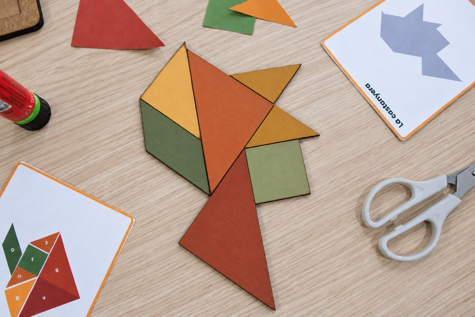 Figura de la castanyera construïda amb les set peces del tangram, acompanyada de targetes de joc